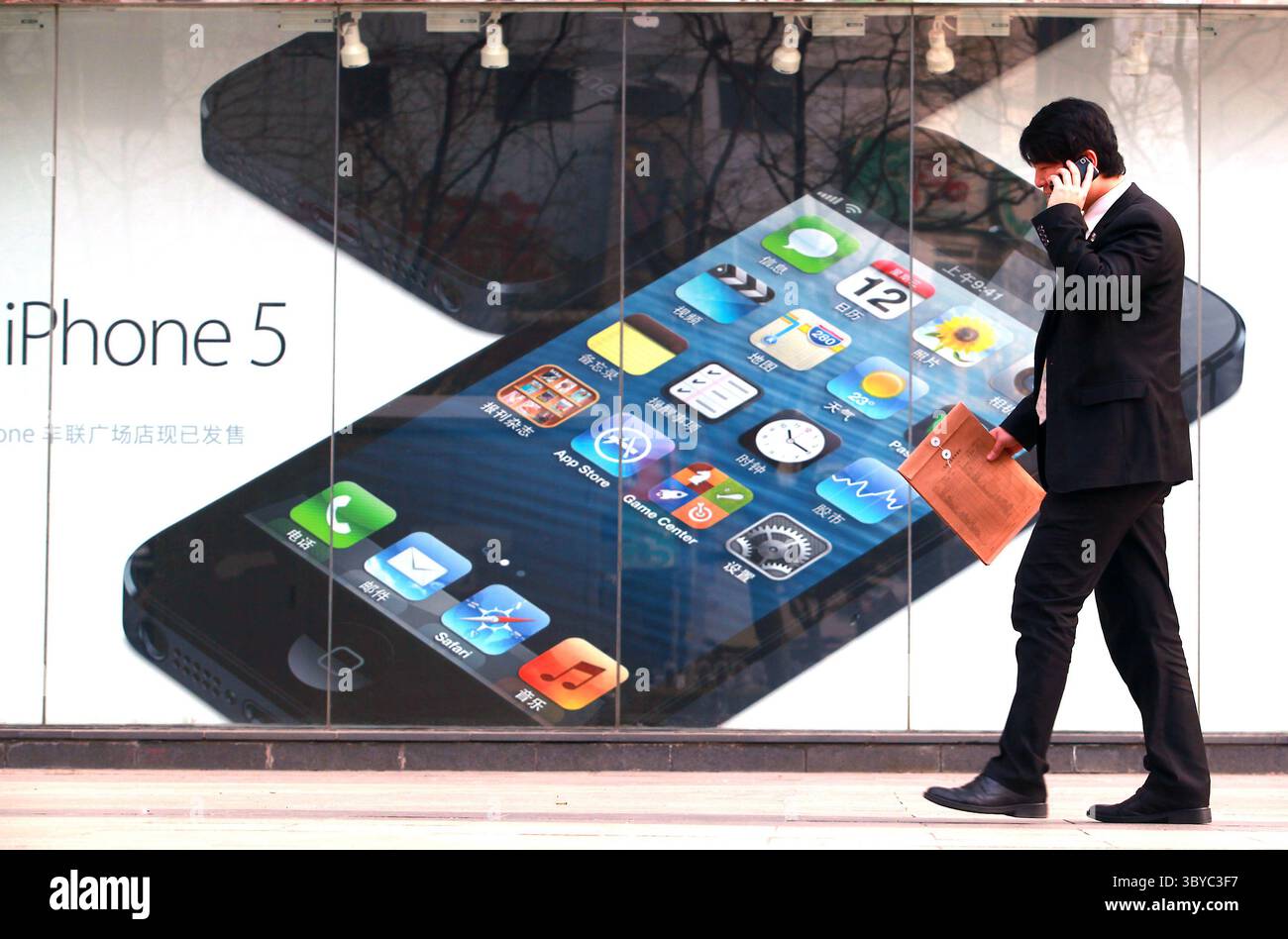 9. April 2013, PEKING, CHINA: Ein Chinese läuft am 9. April 2013 an einem autorisierten Apple-Händler in der Innenstadt von Peking vorbei. Der Chief Executive Officer von Apple Time Cook entschuldigte sich letzte Woche für die Garantie- und Reparaturrichtlinien des Unternehmens für das iPhone in China, nachdem er von staatlichen Medien Kritik am Kundenservice in seinem zweitgrößten Markt erhalten hatte. (Bild: © Stephen Shaver/ZUMA Press Wire) Stockfoto