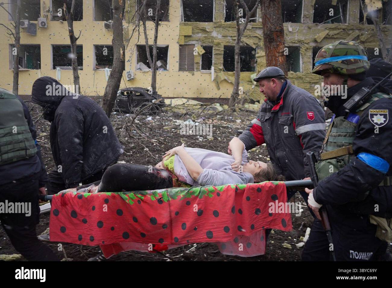 20 Tage in Mariupol (2023) Ukrainische Rettungskräfte und Freiwillige tragen eine verletzte schwangere Frau aus einem Entbindungskrankenhaus, das durch einen Luftangriff in Mariupol, Ukraine, am 9. März 2022 beschädigt wurde. Die Frau wurde in ein anderes Krankenhaus gebracht, überlebte aber nicht. *Filmstill - nur redaktionelle Anwendung* siehe Besondere Hinweise. CAP/TFS-Bild, das von Capital Pictures bereitgestellt wird Stockfoto