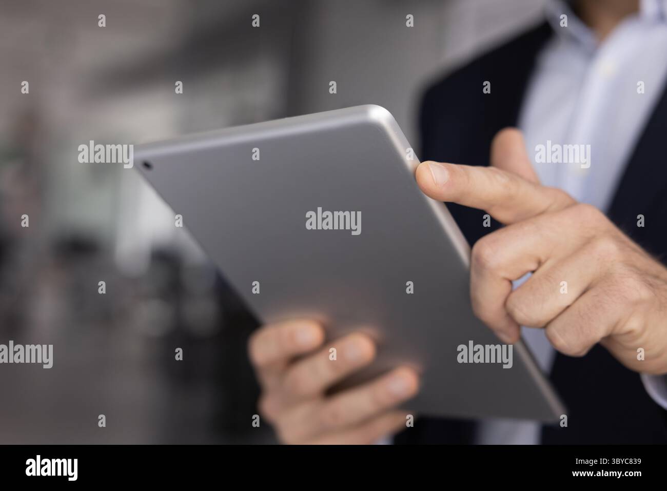 Nahaufnahme eines professionellen Mannes, der ein digitales Tablet verwendet Stockfoto