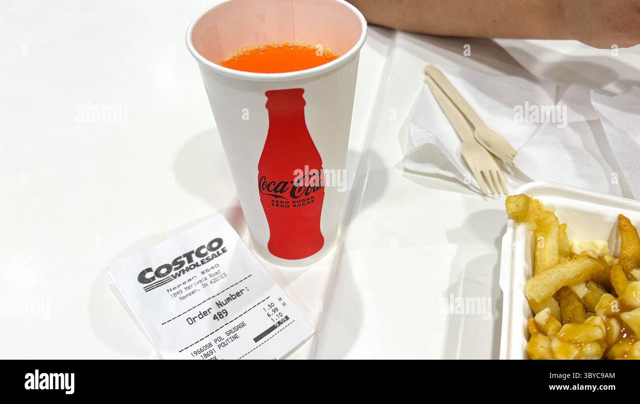 Ottawa, Kanada - 19. Juli 2025: Coca-Cola-Tasse gefüllt mit Orangensoda, Costco Food Court Quittung und Pommes auf dem Tisch mit Kopierraum. trans Stockfoto