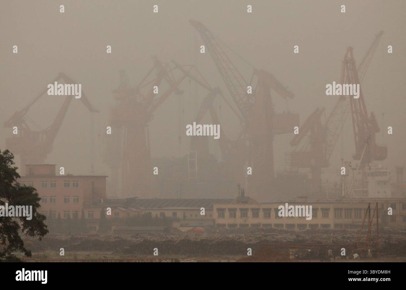 30. August 2011, DALIAN, PROVINZ LIAONNG, CHINA: Alte chinesische Portalkrane entladen trotz starker Regenfälle in der nordöstlichen Hafenstadt Dalian am 30. August 2011 ein riesiges Containerschiff. Der Hafen von Dalian, der nördlichste eisfreie Hafen Chinas, ist auch der größte Mehrzweckhafen im Nordosten Chinas und der zweitgrößte Containerumschlagdrehpunkt auf dem chinesischen Festland. (Bild: © Stephen Shaver/ZUMA Press Wire) Stockfoto