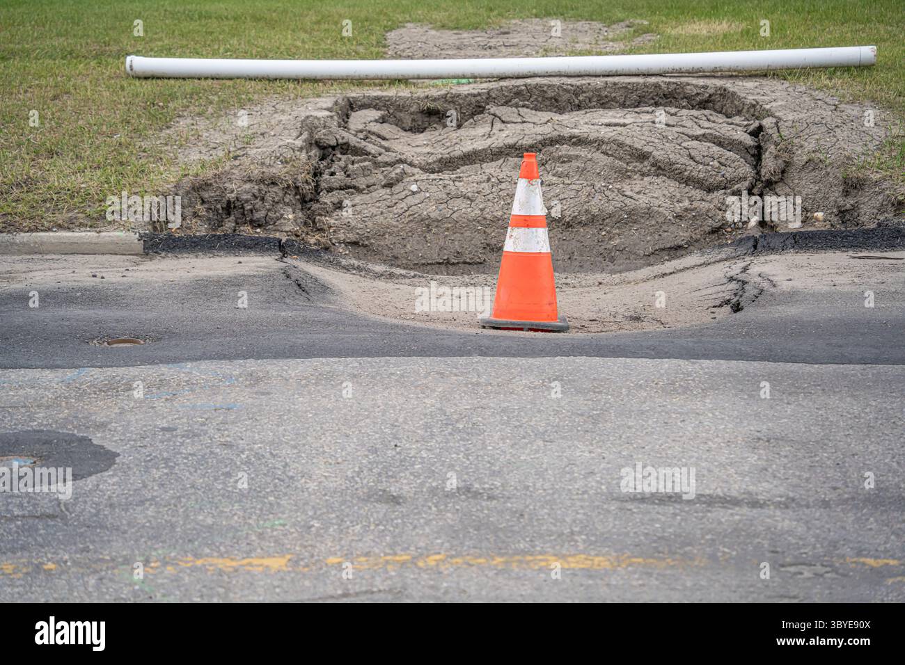 Sinkhole auf einer Straße mit Verkehrskegel Stockfoto