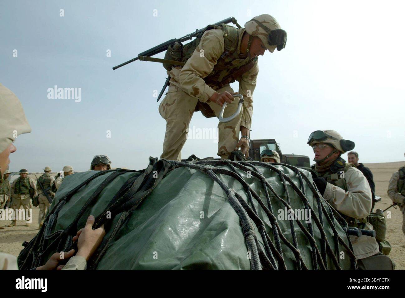 17. Februar 2003 - USA - KRT WORLD NEWS STORY SLUGGED: USIRAQ-DOCS KRT FOTO VON DAVID P. GILKEY/DETROIT FREIE PRESSE (25. Februar) US Marines und Navy Doctors, die der 7th Regimental Combat Support Company 117 angehören, entladen am 18. Februar 2003 medizinische Vorräte im Norden Kuwaits. Die Einheit betreibt eine mobile Notaufnahme, die die Lücke zwischen Fronttriage und OP-Räumen im Heck überbrückt. (lde) 2003 (Bild: © Detroit Free Press via ZUMA Press Wire) Stockfoto