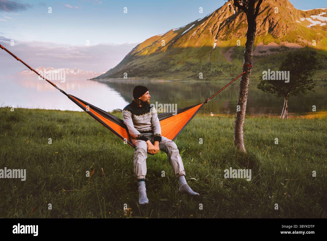 Mann chillen in Hängematte alleine in Norwegen Outdoor Campingausrüstung Sommerurlaub Reisende genießen Berg- und Fjordblick Öko-Tourismus Abenteuer Stockfoto