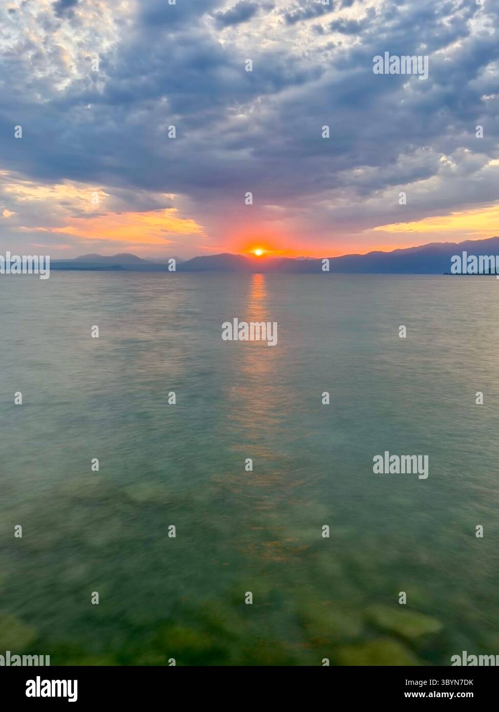 Sonnenuntergang über dem Gardasee von Cisano in der Nähe von Bardolino mit blauem Wasser Stockfoto