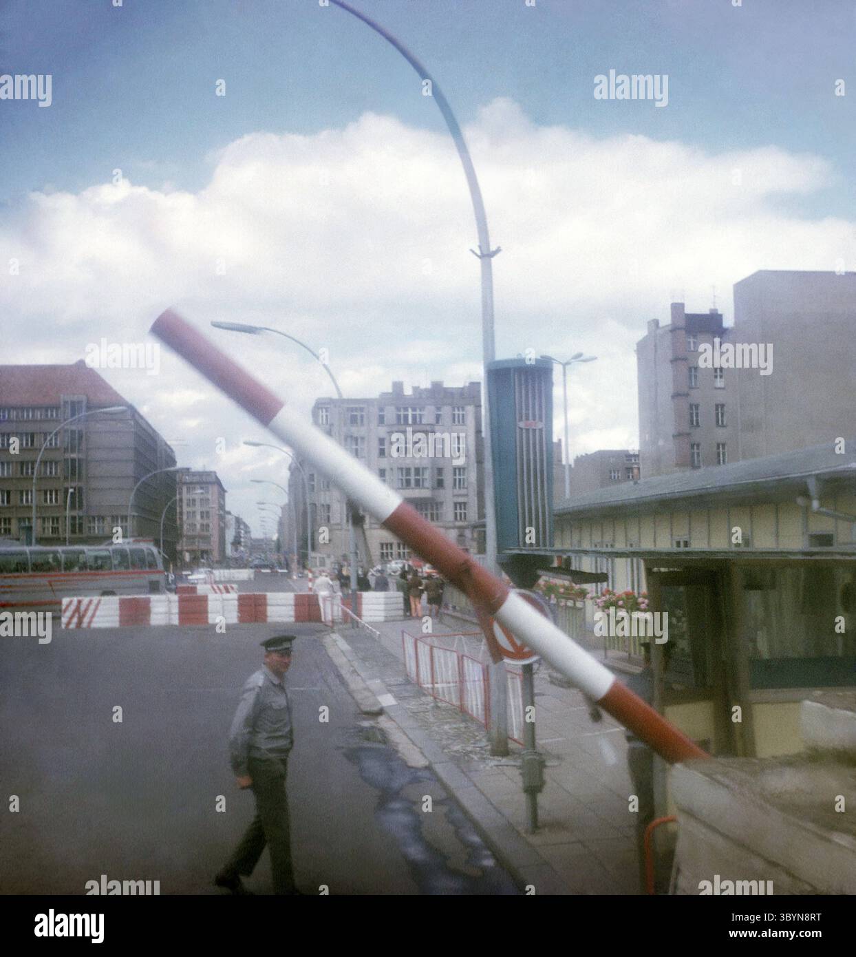 Schlagbäume und vermutlich ein DDR-Grenzsoldat am alliierten Grenzübergang Checkpoint Charlie in der Friedrichstraße in Berlin. Der Grenzübergang dient als Kontrollpunkt für Angehörige des Militärpersonals der West-Alliierten und verbindet den sowjetischen Sektor Berlin mit dem US-amerikanischen Sektor. / Barrieren und vermutlich ein DDR-Grenzwächter am Alliierten Grenzübergang am Checkpoint Charlie in der Friedrichstraße in Berlin. Der Grenzübergang dient als Kontrollpunkt für Angehörige des Militärs der Westalliierten und verbindet den sowjetischen Sektor Berlins mit dem US-Sektor Stockfoto