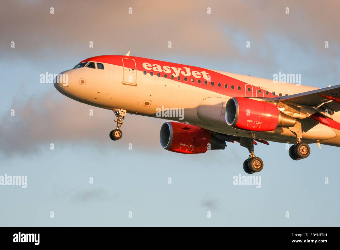 der easyJet airbus a320 landet bei einem wunderschönen Sonnenuntergang am Flughafen lissabon humberto delgado Stockfoto