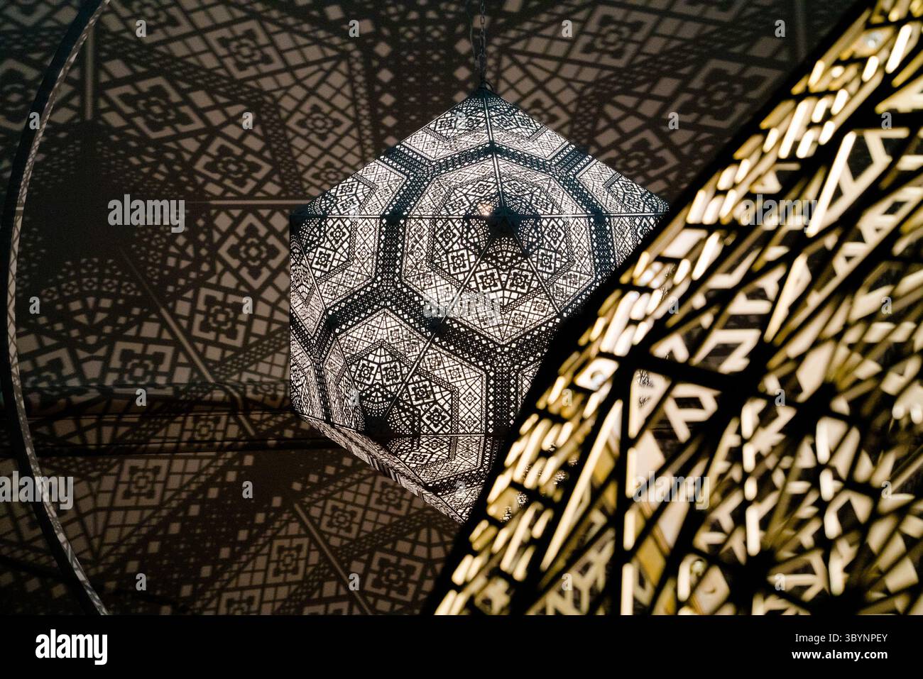 In D.C. wirft eine Hängeleuchte einen geometrischen Schatten auf die Decke und spiegelt das Design einer benachbarten Struktur wider, was einen fesselnden Effekt erzeugt. Stockfoto