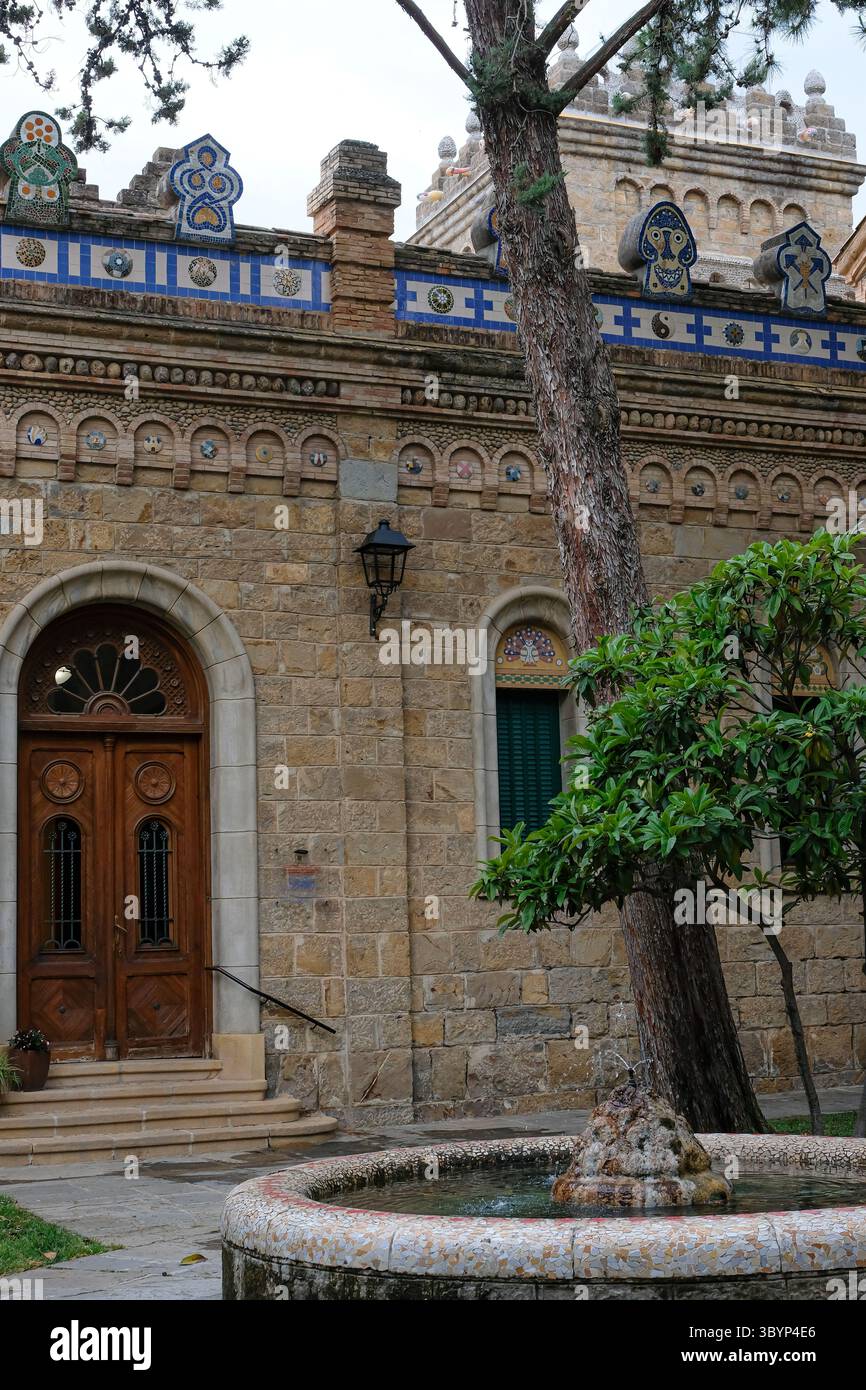 Brunnen in der Nähe der bogenförmigen Eingangstür. Torre Mauri La Pobla de Segur, Katalonien, Spanien. Historisches Rathaus aus Stein, 1907 katalanisches Erbe. Stockfoto