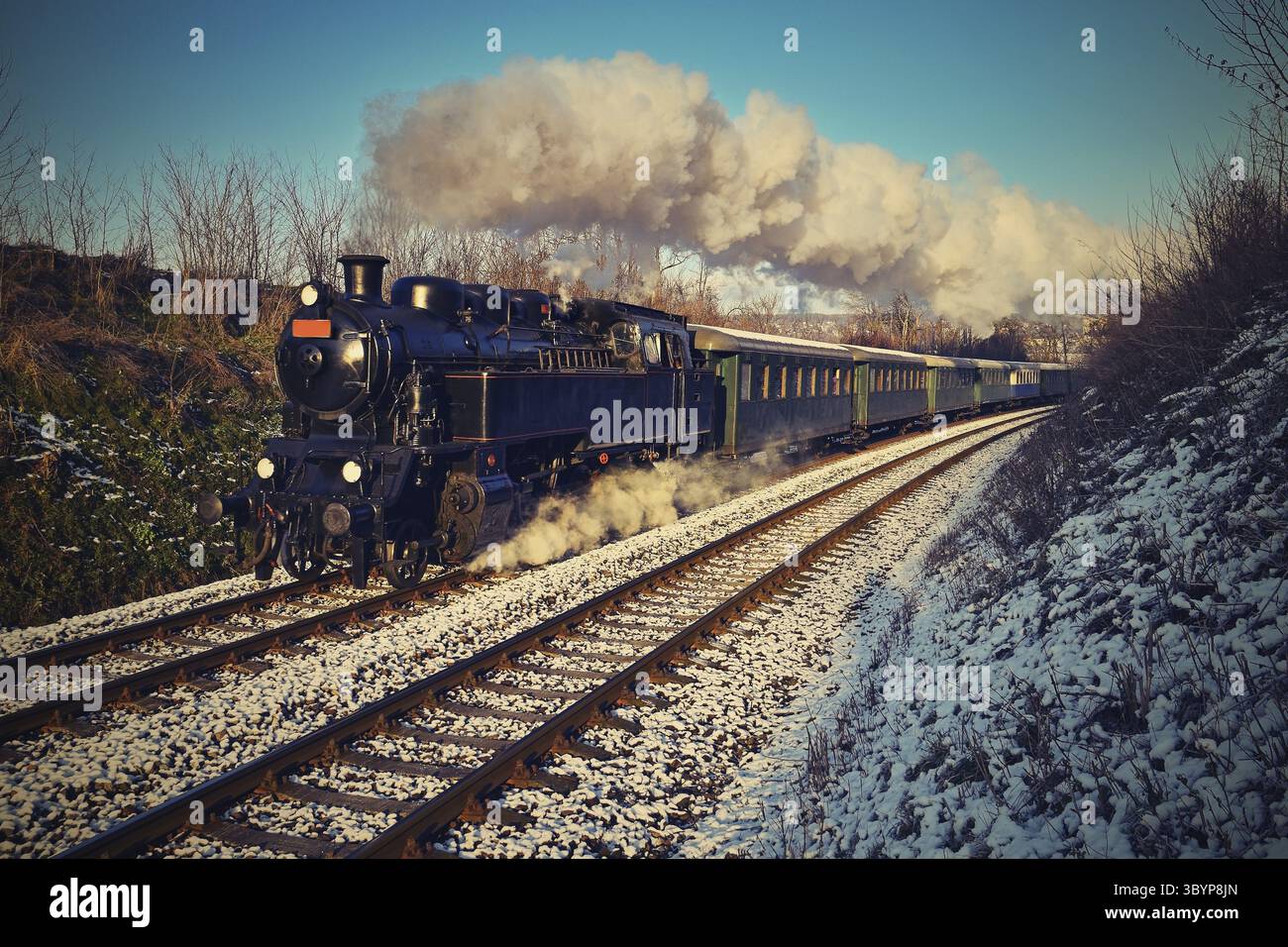 Wunderschöne alte Dampfeisenbahn mit Wagen, die bei Sonnenuntergang auf Schienen fahren. Ausflüge für Kinder und Eltern an festlichen besonderen Tagen. Tschechische Republik Europa Stockfoto