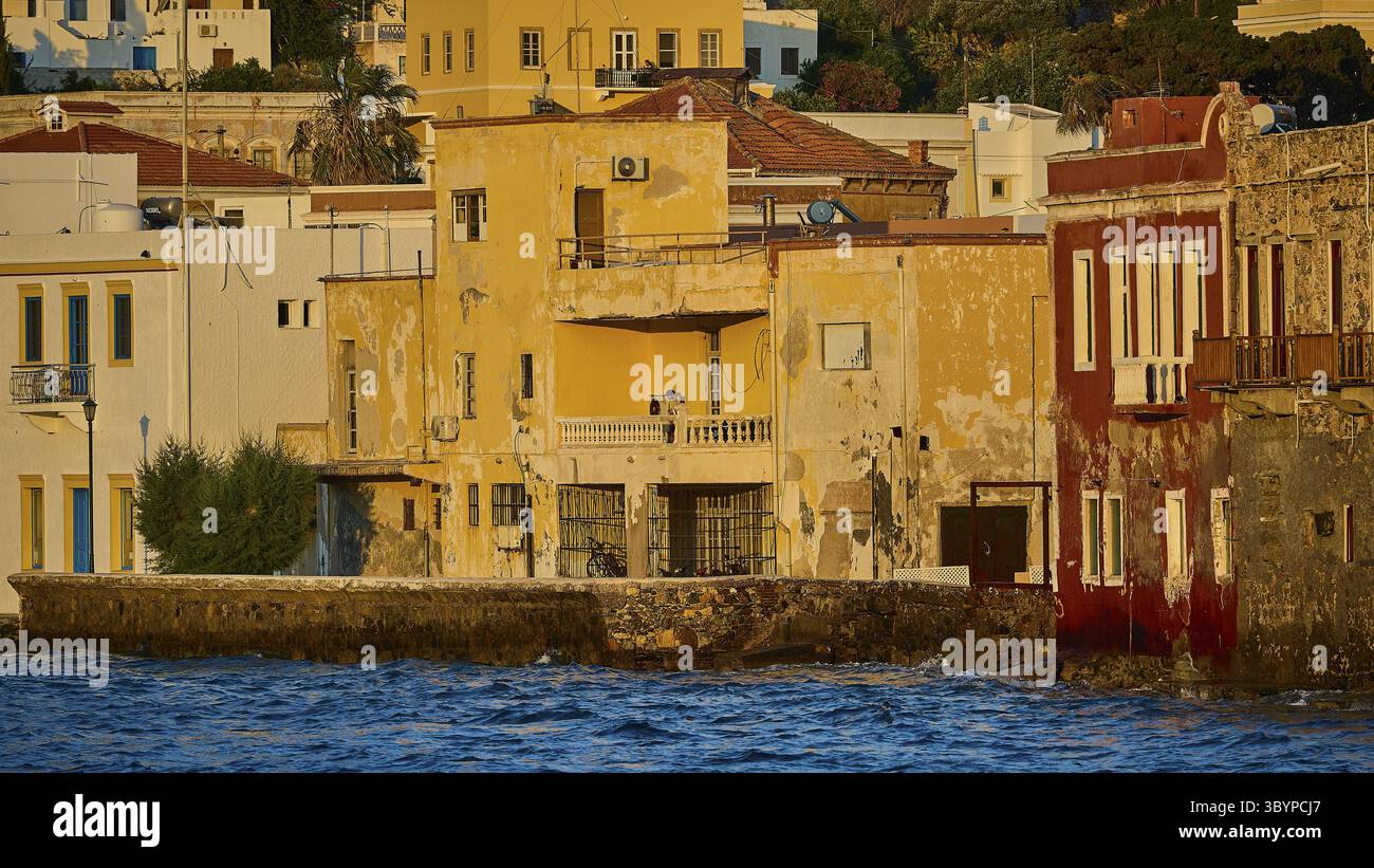 Alte, farbenfrohe Gebäude auf dem Wasser, beleuchtet von der Abendsonne, ruhige Küstenatmosphäre, Agia Marina, Leros, Dodekanese, Griechische Inseln, Griechenland Stockfoto Alte, farbenfrohe Gebäude auf dem Wasser, beleuchtet von der Abendsonne, ruhige Küstenatmosphäre, Agia Marina, Leros, Dodekanese, Griechische Inseln, Griechenland Stockfoto