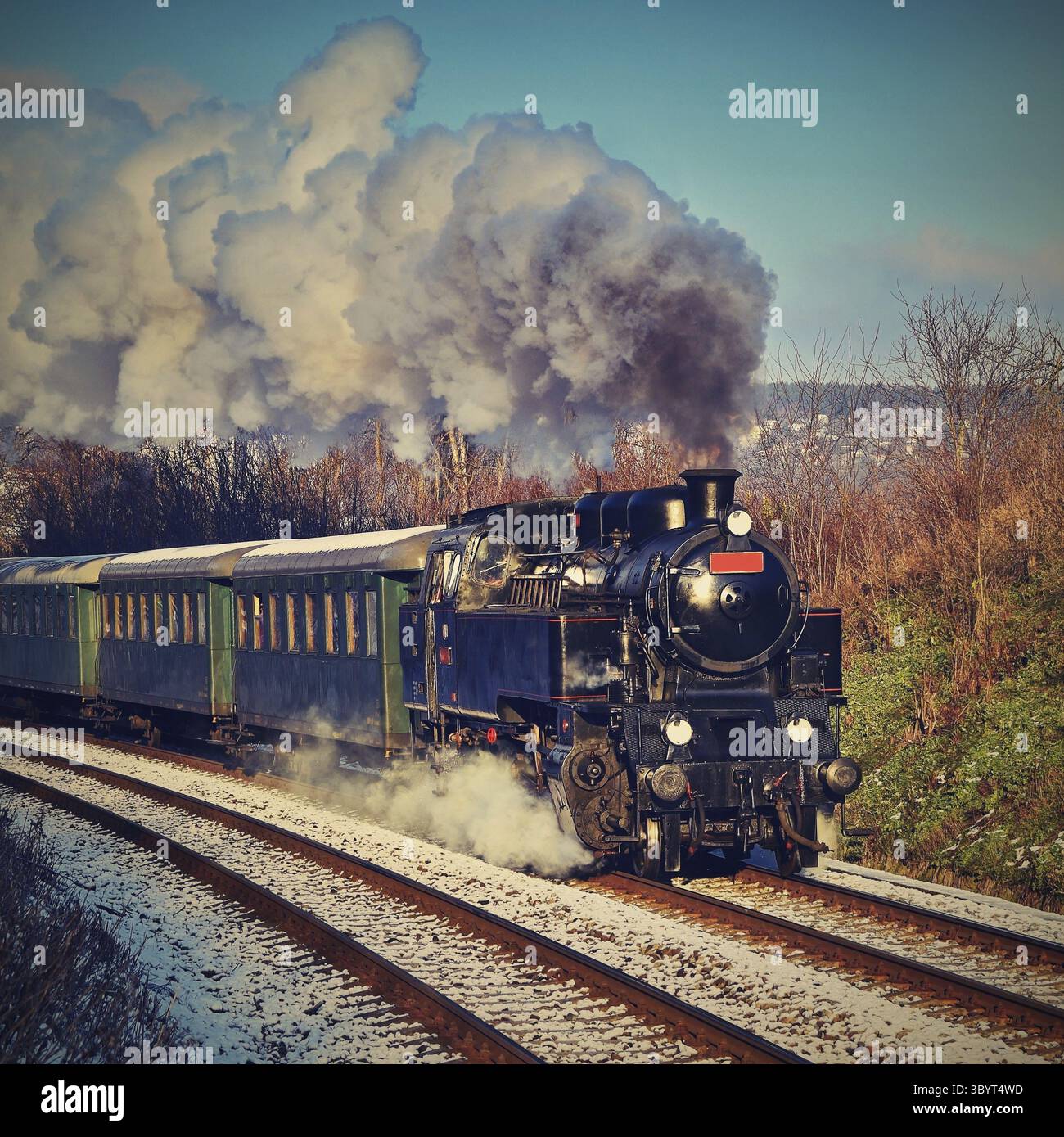 Wunderschöne alte Dampfeisenbahn mit Wagen, die bei Sonnenuntergang auf Schienen fahren. Ausflüge für Kinder und Eltern an festlichen besonderen Tagen. Tschechische Republik Europa Stockfoto
