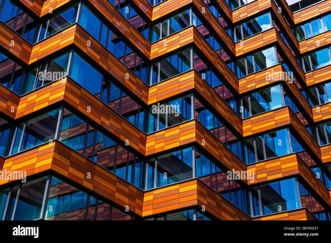 Bürogebäude mit orangefarbenen und braunen horizontalen Paneelen Stockfoto