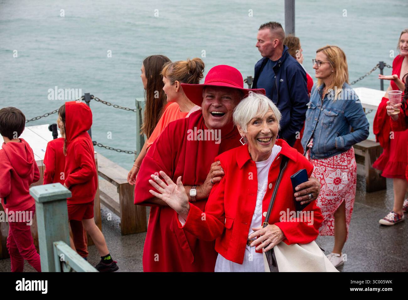 Folkestone, Großbritannien. Juli 2025. Die Fans winken nach der Vorstellung am Folkestone Pier in die Kamera. Hunderte von Kate Bush Fans versammelten sich in roten Kleidern am Folkestone Pier, um den Most Wuthering Heights Day oder den Kate Bush Day mit Tanz zu feiern. Quelle: SOPA Images Limited/Alamy Live News Stockfoto