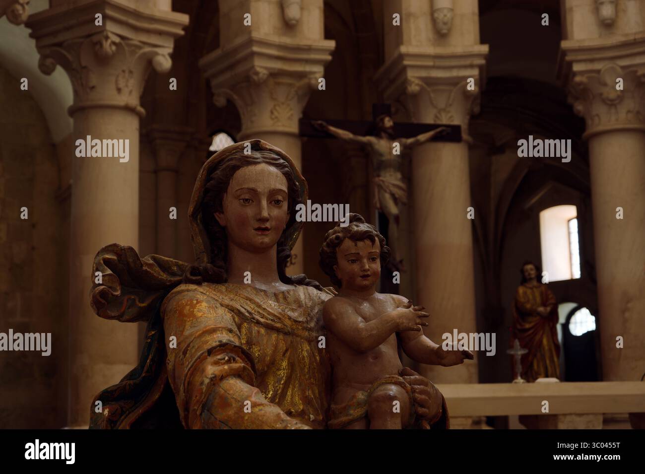 Polychrome Skulptur der Madonna und des Kindes unter gewölbten Säulen in der Klosterkirche von Alcobaca Stockfoto