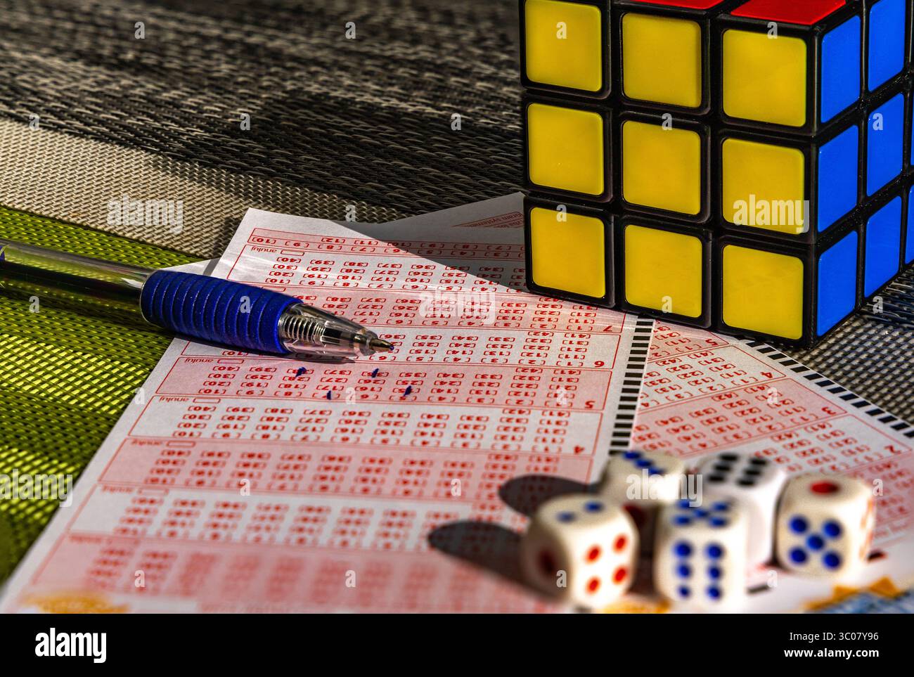 Das Ausstreichen von Glückszahlen in einer großen Geldverlosung, ein Lottoticket, das Markieren von Zahlen mit einem Stift auf einem Spielschein Stockfoto