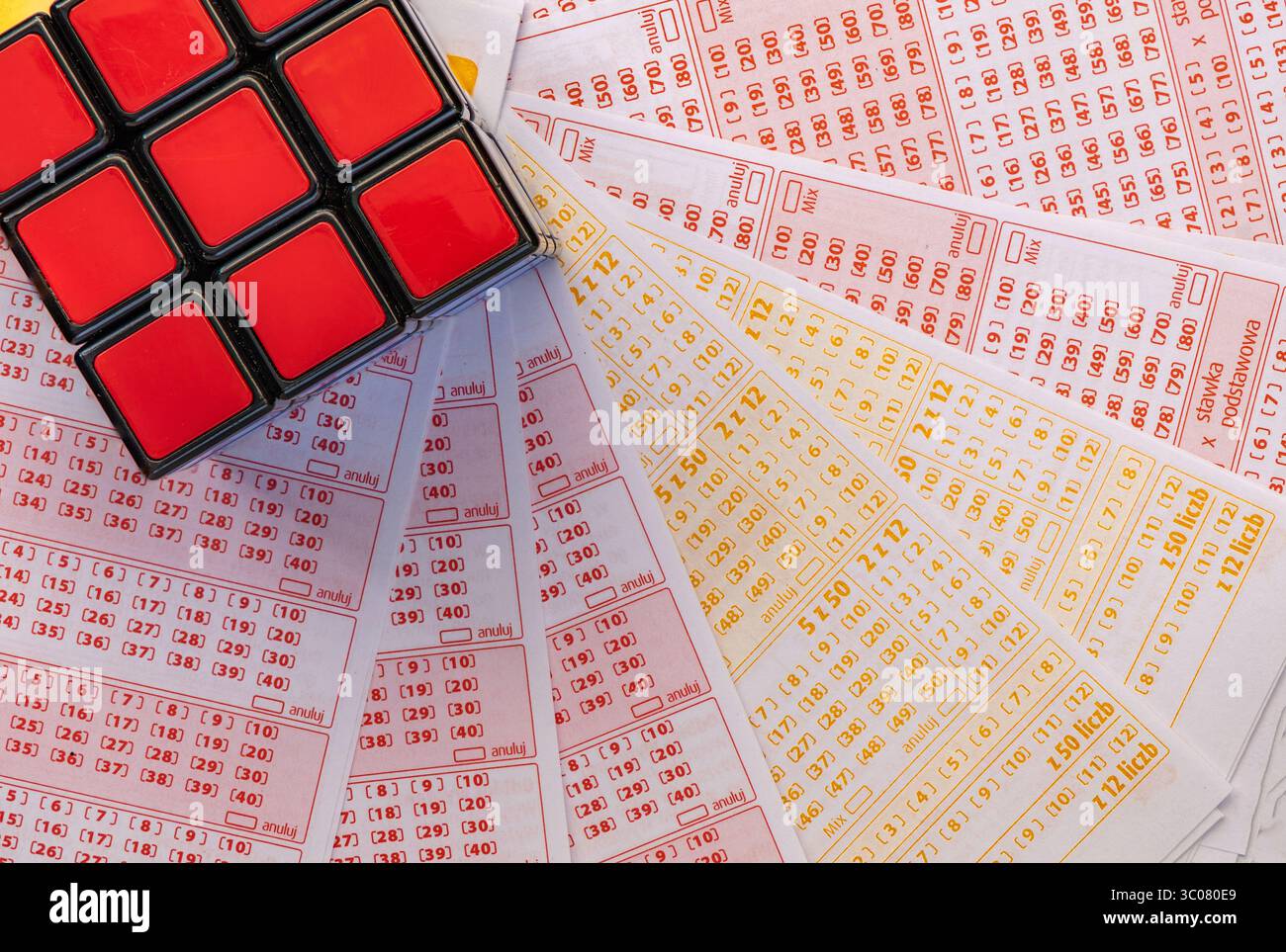 Glücksspiele, bunte Würfel, die über Lottoscheine in die Luft geworfen werden, sucht nach Zahlenspielen und Lotterien Stockfoto