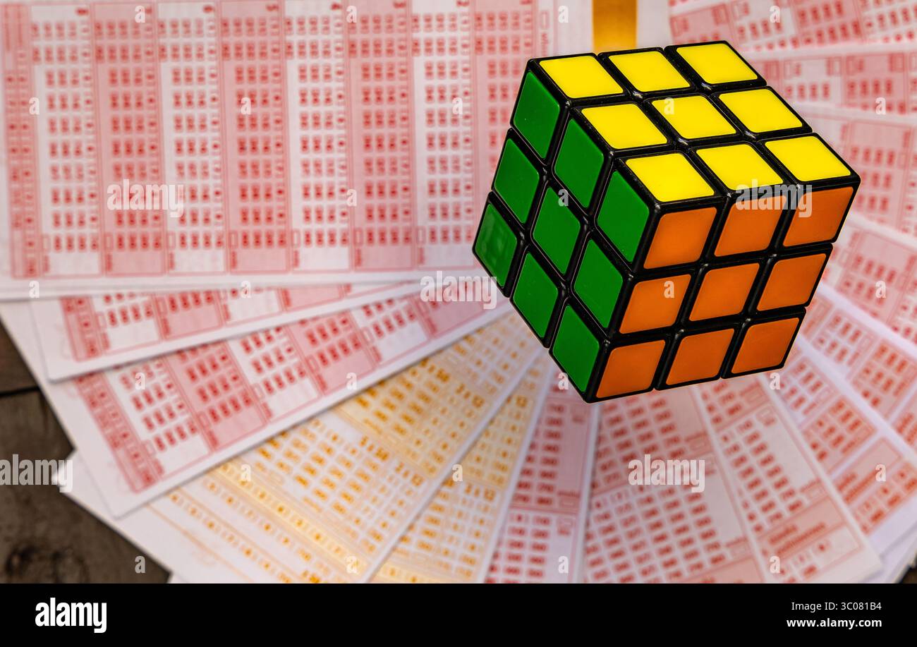 Glücksspiele, bunte Würfel, die über Lottoscheine in die Luft geworfen werden, sucht nach Zahlenspielen und Lotterien Stockfoto