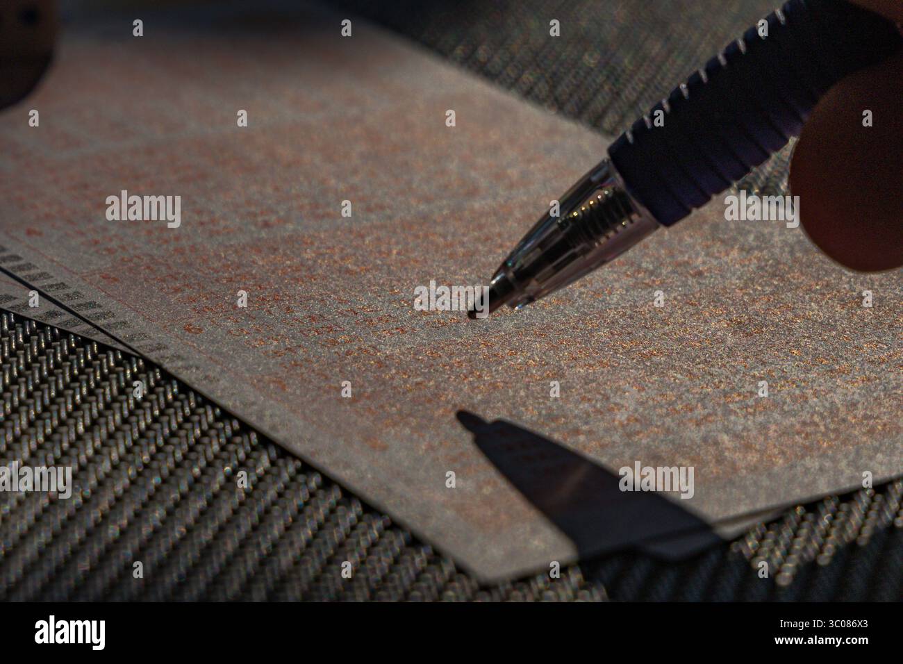 Das Ausstreichen von Glückszahlen in einer großen Geldverlosung, ein Lottoticket, das Markieren von Zahlen mit einem Stift auf einem Spielschein Stockfoto