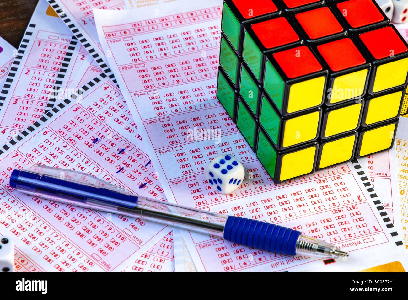 Das Ausstreichen von Glückszahlen in einer großen Geldverlosung, ein Lottoticket, das Markieren von Zahlen mit einem Stift auf einem Spielschein Stockfoto