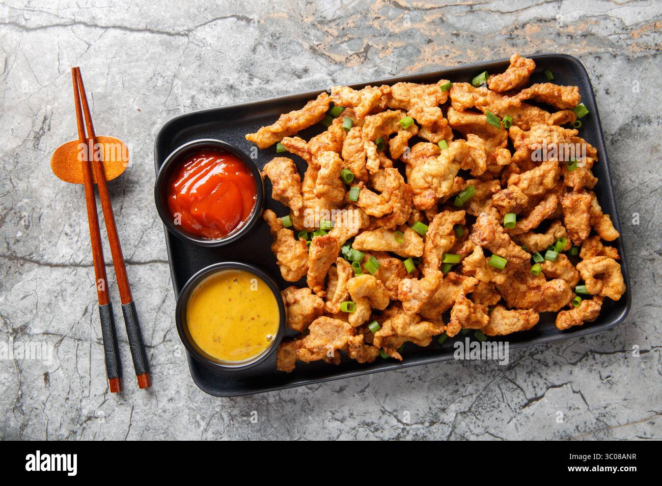 Sichuan Pepper Studded Crispy Pork Xiaosurou Nahaufnahme auf dem Teller auf dem Tisch. Horizontale Draufsicht von oben Stockfoto