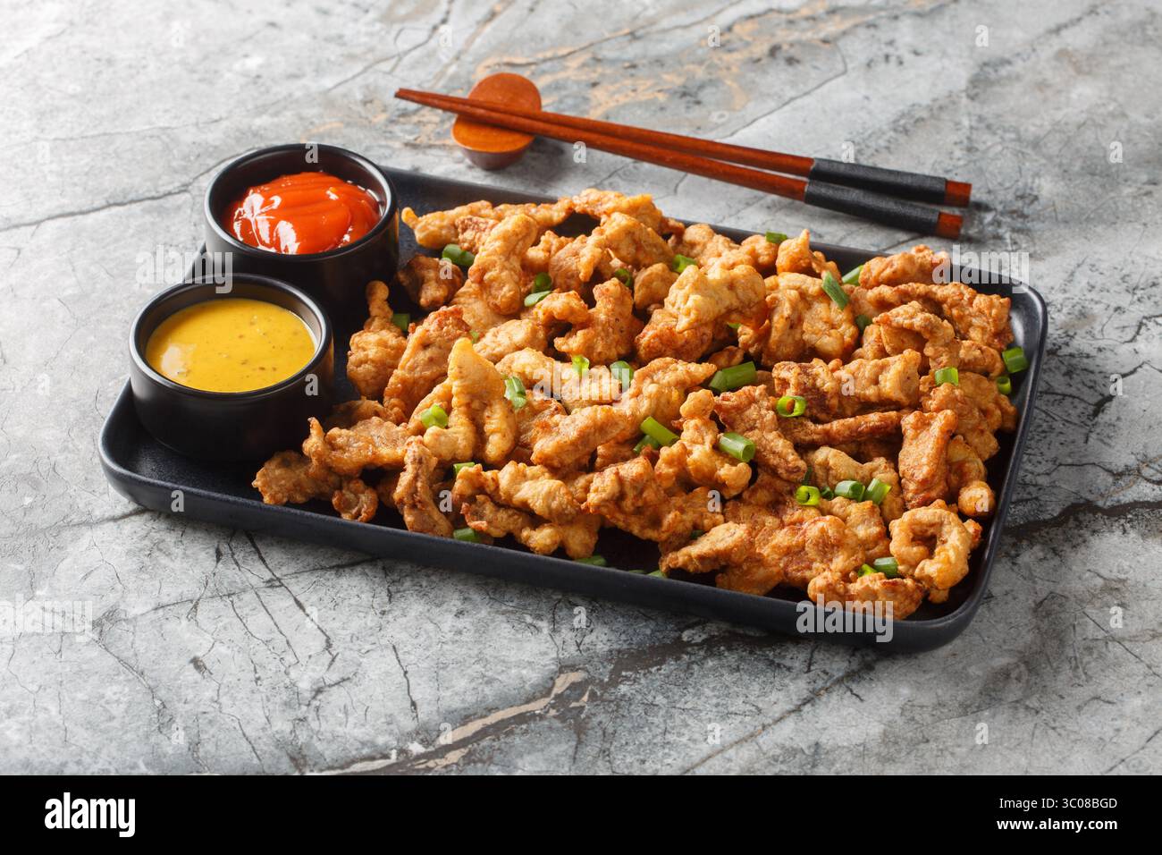 Sichuan Pepper Studded Crispy Pork Xiaosurou Nahaufnahme auf dem Teller auf dem Tisch. Horizontal Stockfoto
