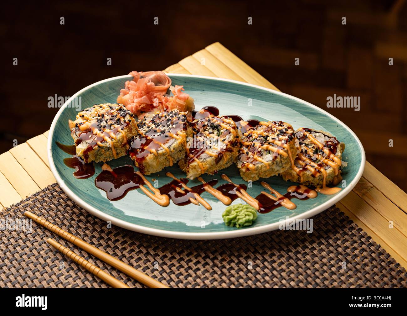 Heiße gebratene Sushi-Brötchen liegen auf Teller mit Wasabi und Ingwer Stockfoto