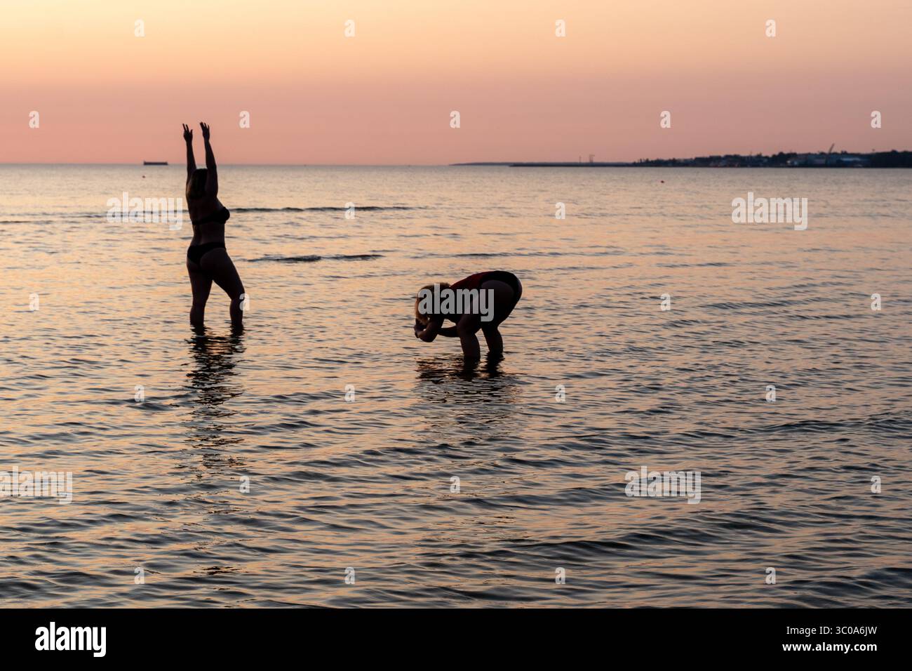 Reife Frau posiert selbstbewusst am Pirita Beach bei Sonnenuntergang Stockfoto