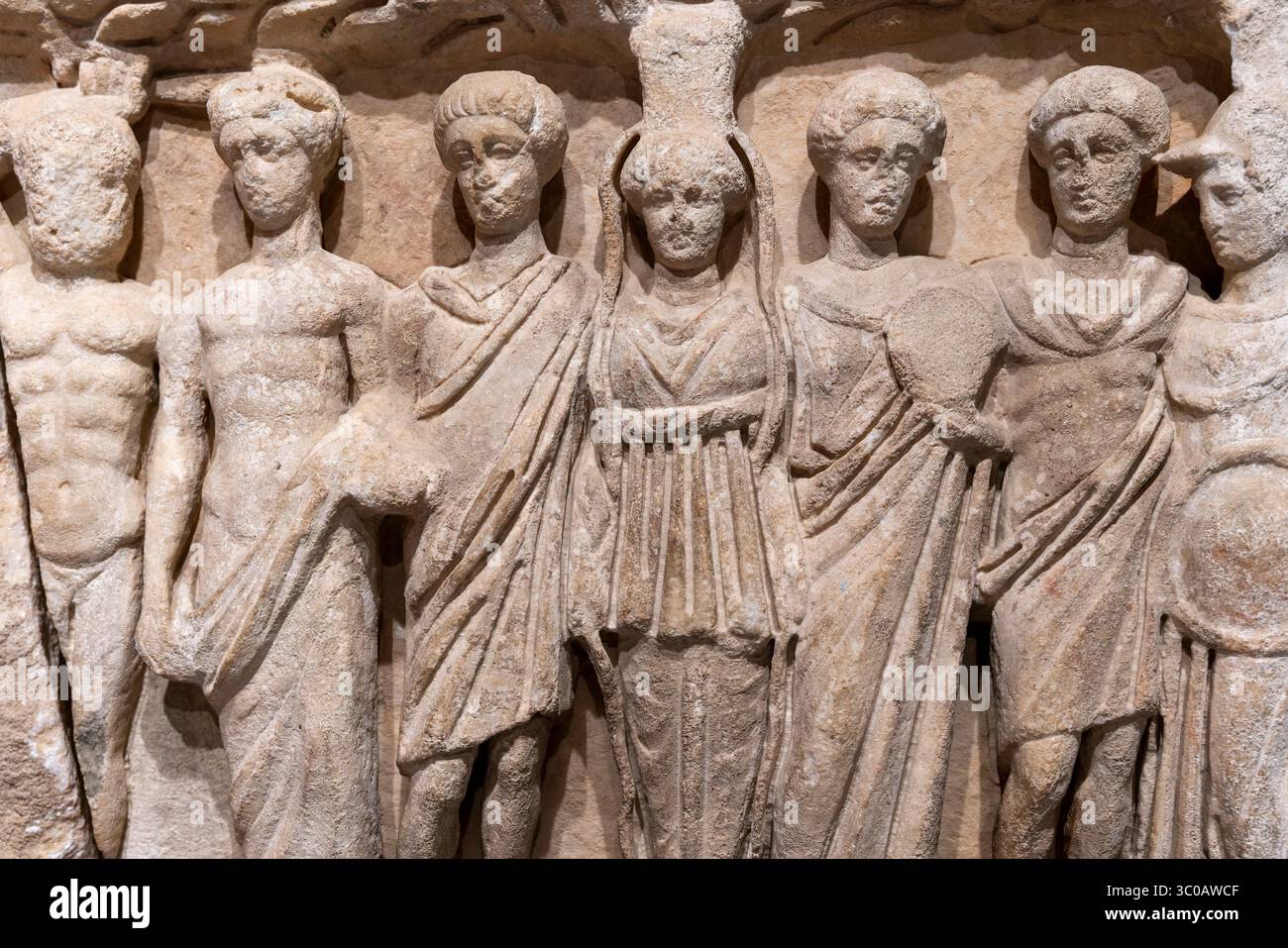 Goldenes Sonnenlicht strahlt auf dem antiken Marmor von Ephesus, Türkei, und beleuchtet römische Figuren, die in ewigem Dialog und handwerklicher Anmut geformt wurden. Stockfoto