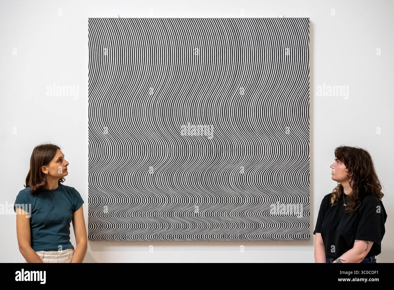 London, Großbritannien. 21. Juli 2025. Mitarbeiter mit dem neu restaurierten „Fall“, 1963, von Bridget Riley bei einer neuen Ausstellung von Werken von Bridget Riley im Tate Britain, die weiterhin die sensorische Erfahrung des Sehens erforschen. Quelle: Stephen Chung / Alamy Live News Stockfoto London, Großbritannien. 21. Juli 2025. Mitarbeiter mit dem neu restaurierten „Fall“, 1963, von Bridget Riley bei einer neuen Ausstellung von Werken von Bridget Riley im Tate Britain, die weiterhin die sensorische Erfahrung des Sehens erforschen. Quelle: Stephen Chung / Alamy Live News Stockfoto