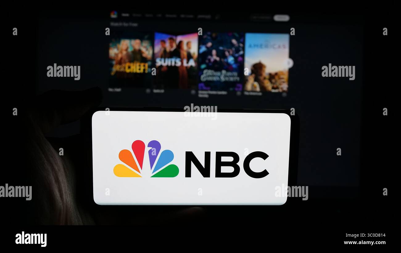 Stuttgart, Deutschland - 25.05.2025: Person mit Mobiltelefon mit Logo des Netzes National Broadcasting Company (NBC) auf dem Bildschirm vor der Webseite. Stockfoto
