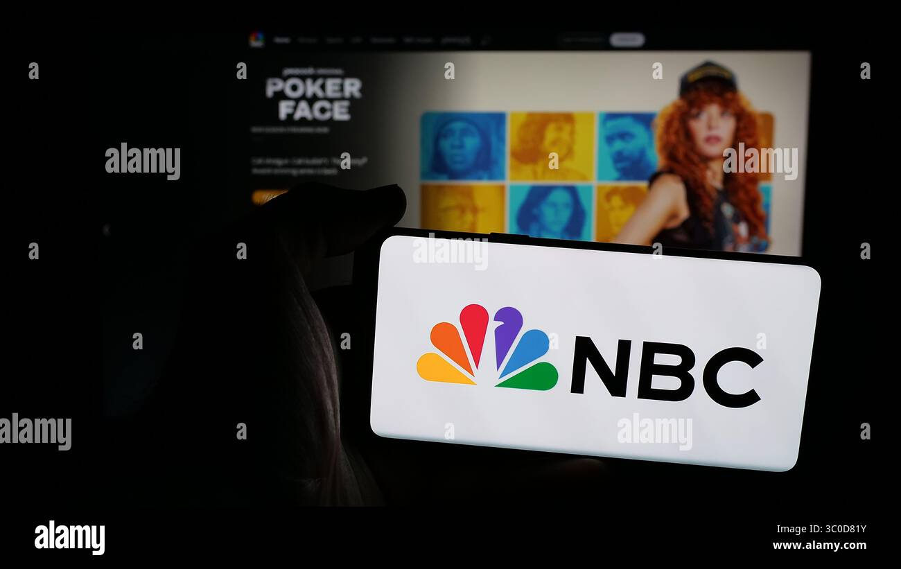 Stuttgart, Deutschland - 25.05.2025: Person, die ein Mobiltelefon mit dem Logo des Netzes National Broadcasting Company (NBC) auf dem Bildschirm vor der Webseite hält. Stockfoto