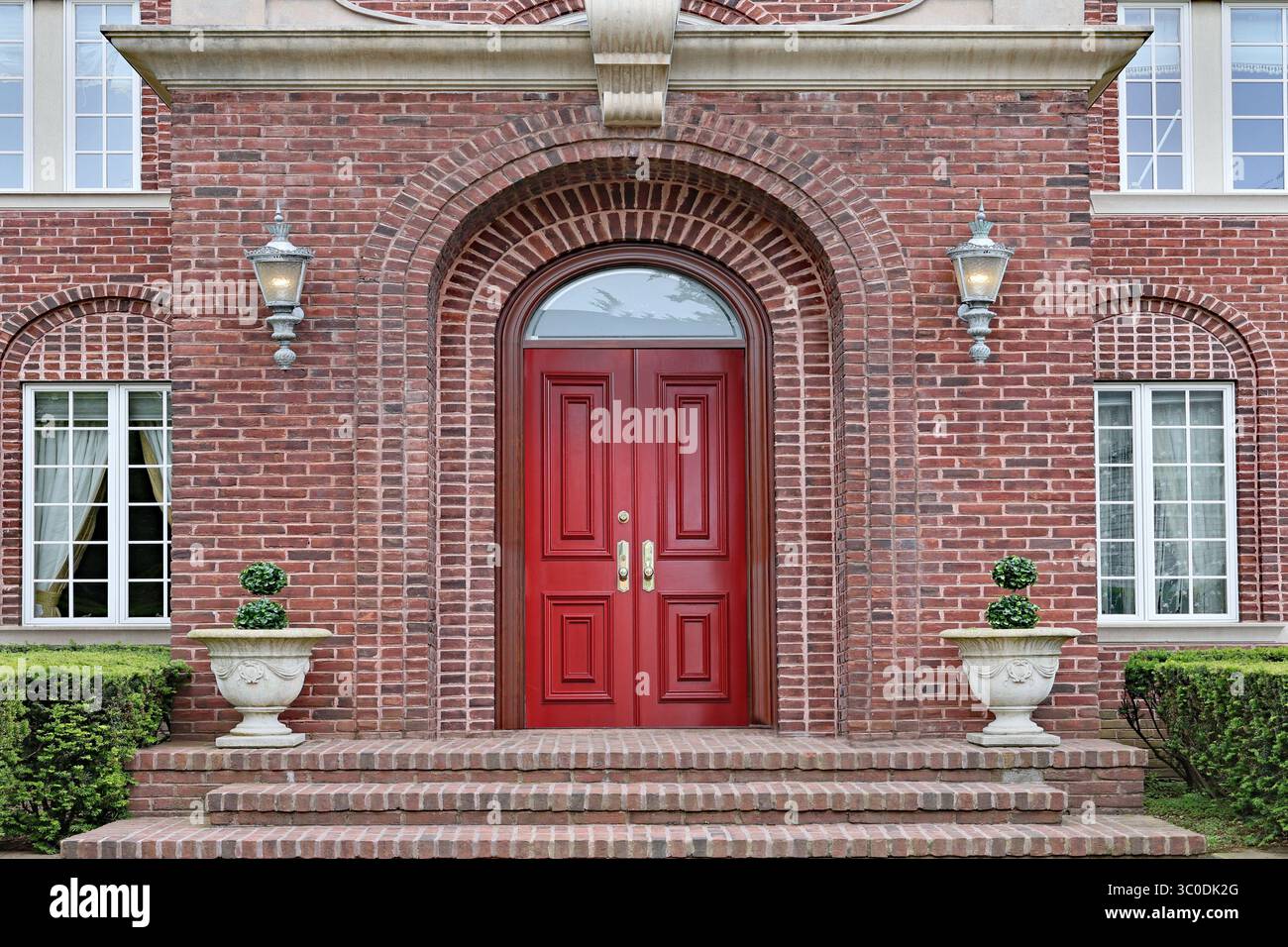 Eingang zum Backsteinhaus mit kastanienfarbener Doppeltür Stockfoto