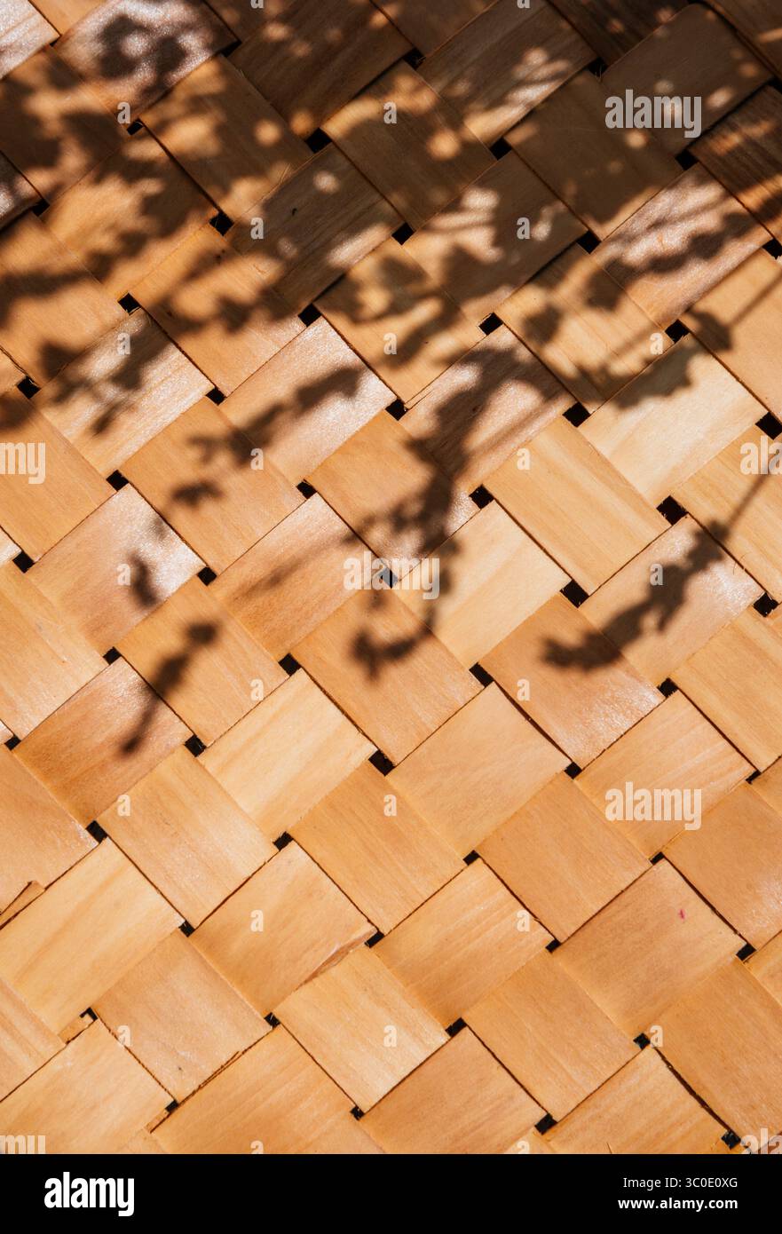 Aus Bambus gewebter Strohkorb mit tropischem Farbüberzug. Sommerstrand im ästhetischen Hintergrund. Minimales Outdoor-Design aus natürlichem Rattan. Stockfoto