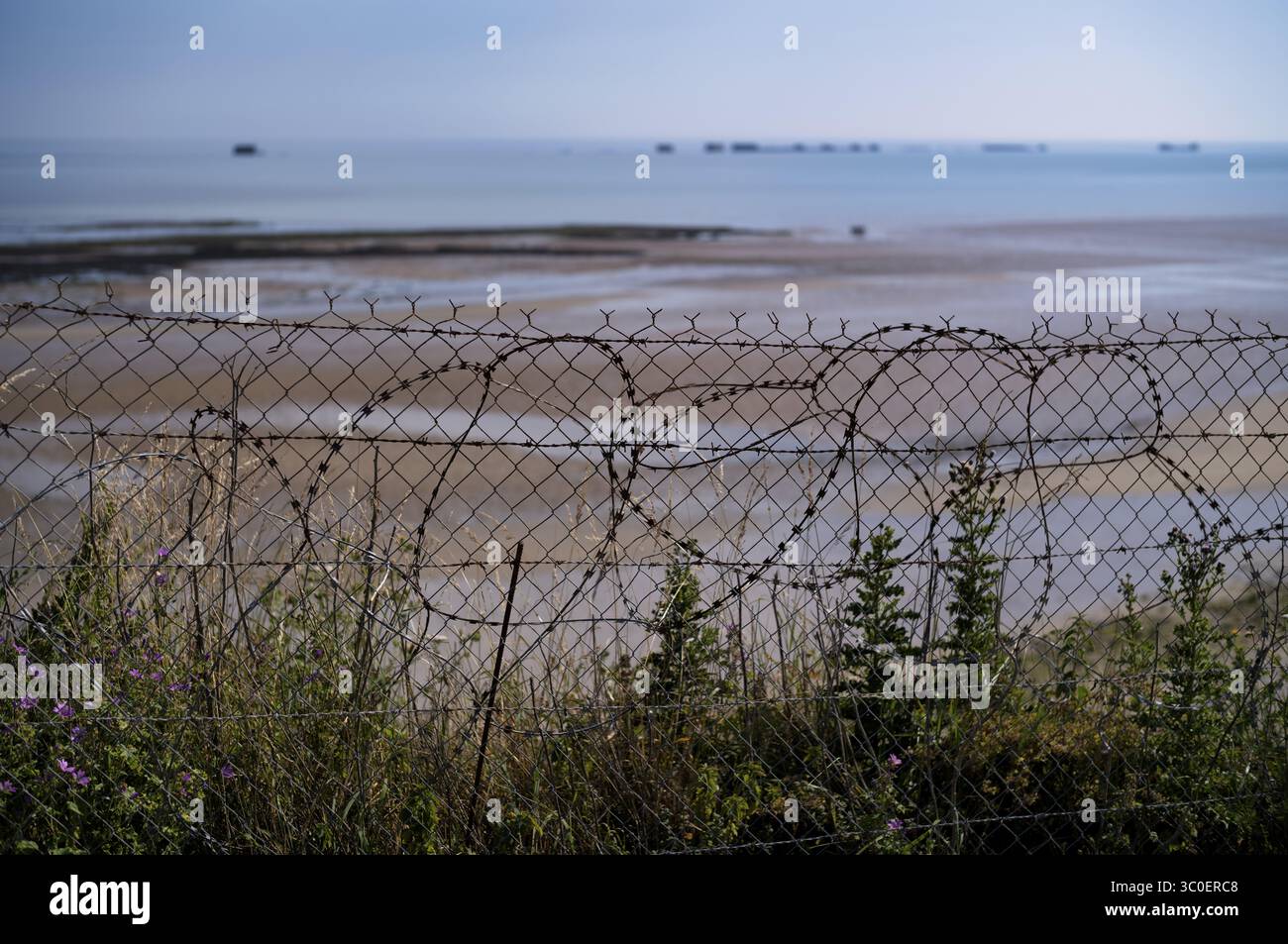 Stacheldraht vor Phoenix Caissons, Caissons und Betonkisten wurden im Meer als Wellenbrecher und als improvisierter Hafen, Mulberry B, verwendet Stockfoto