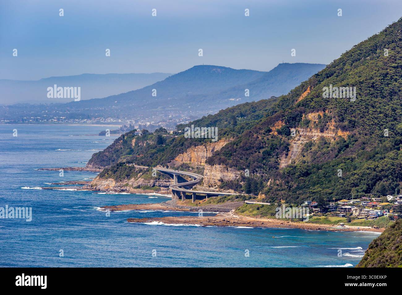 Ein wunderschöner Blick aus der Vogelperspektive auf Clifton und Sea Cliff Bridge mit Sandstrand und Wellen, die an der Küste krachen. Der Strand wird von üppigen grünen Klippen A begrenzt Stockfoto
