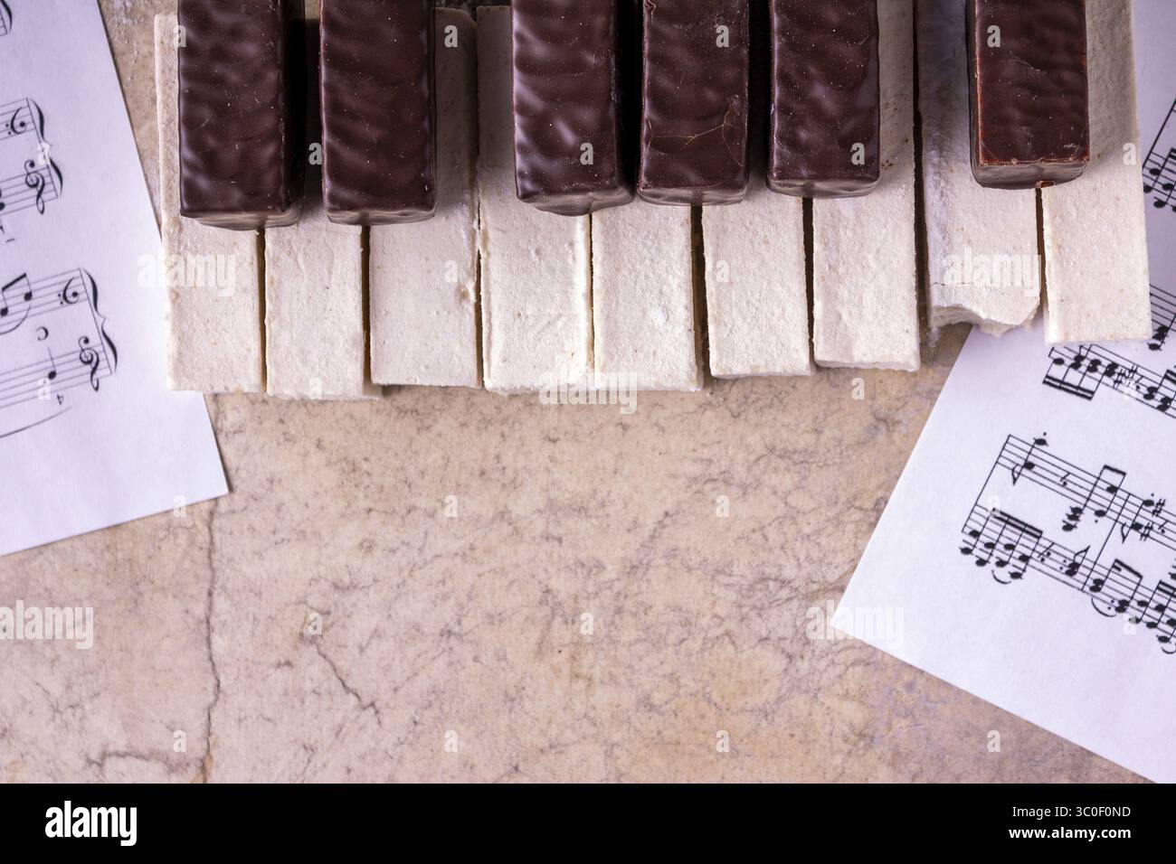 Klavier mit abgebissenen Marshmallows auf beigefarbenem Hintergrund Stockfoto