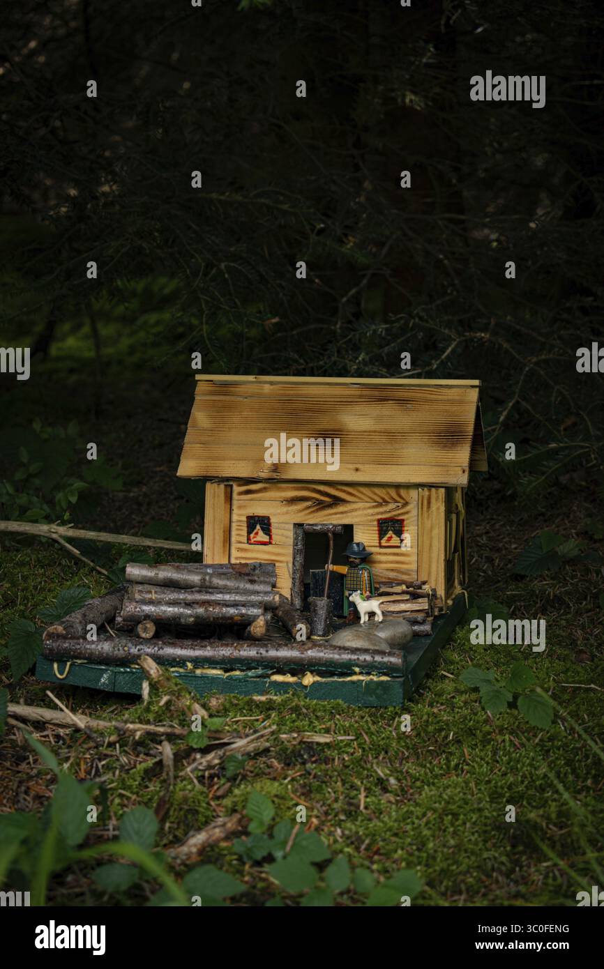 Eine kleine selbstgebaute Holzhütte im Wald mit Playmobil-Figur und kleiner Ziege, Bayern, Deutschland Stockfoto
