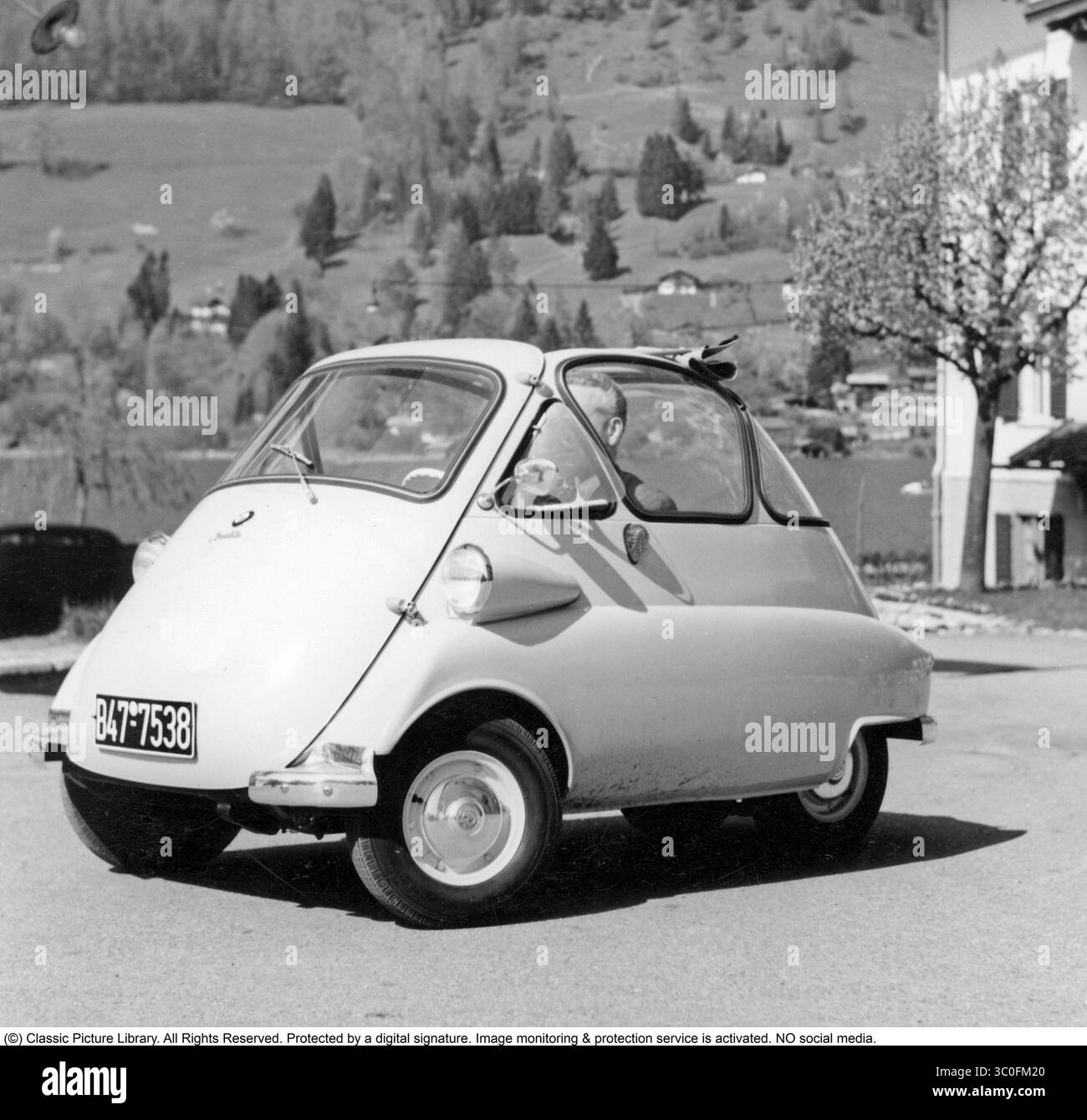 Fahren in den 1950er Jahren BMW Isetta, 1955. Auf einem Foto aus dem Jahr 1955 wurde der BMW Isetta, ein skurriler Kleinwagen mit einem unverwechselbaren Ei-Design und einer nach vorne öffnenden Tür, zu einer Sensation der Nachkriegszeit. Angetrieben von einem 247 ccm Einzylindermotor mit 12 PS erreichte er eine Höchstgeschwindigkeit von etwa 85 km/h. Die Isetta ist in städtischen Umgebungen beliebt und half BMW in den 1950er Jahren, finanzielle Herausforderungen zu meistern Stockfoto