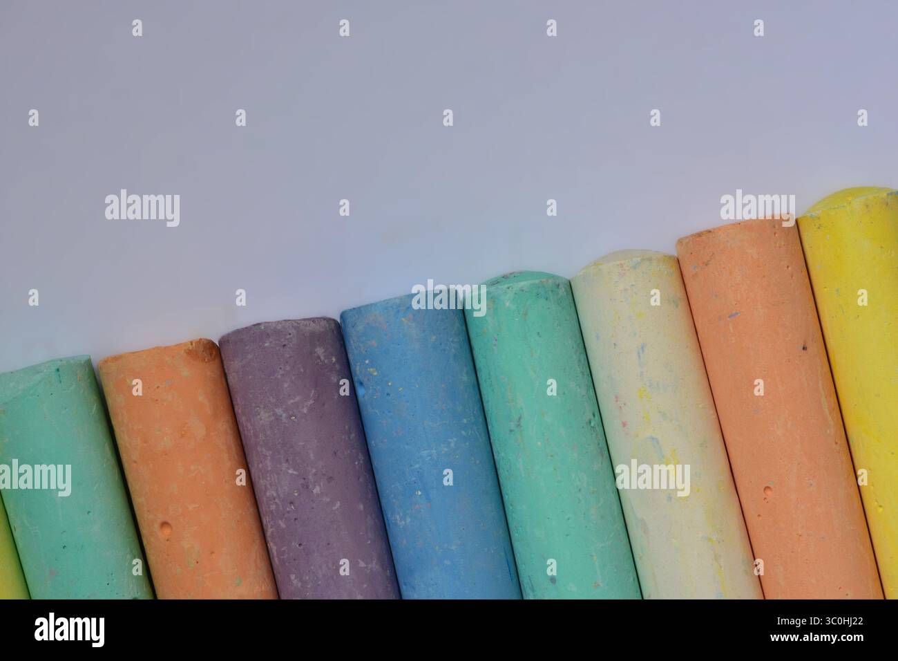 Nahaufnahme pastellfarbener Kreidestäbchen in diagonaler Anordnung. Künstlerische Textur und Farbvielfalt geeignet für Bildung, Kreativität oder Stockfoto