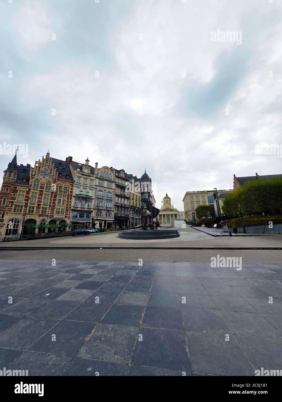 Erhöhter Blick auf den formellen Garten des Mont des Arts mit getrimmten Hecken und die Brüsseler Skyline im Hintergrund. - Smartphone-aufgenommenes Stockfoto