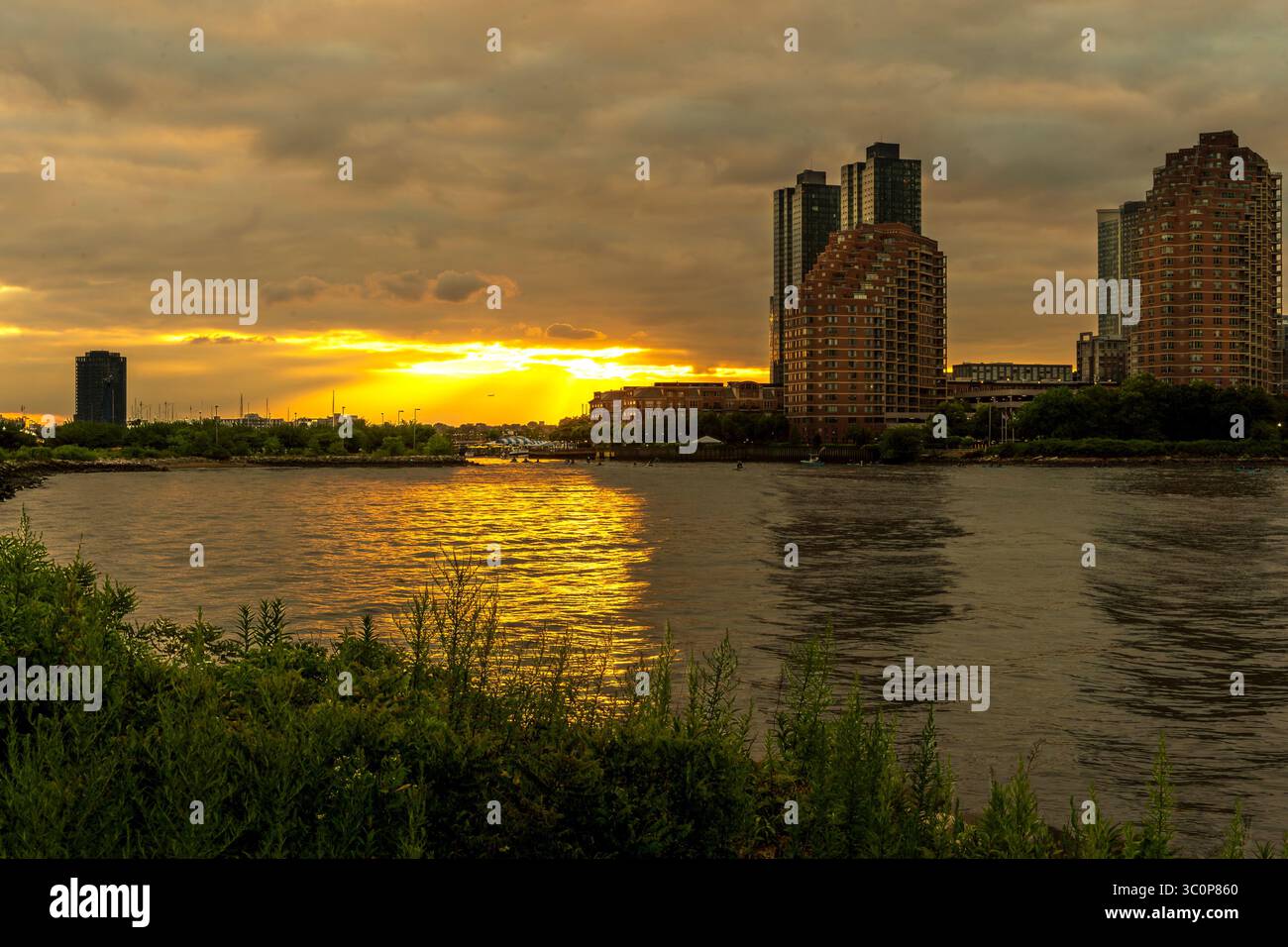 Jersey City, NJ - USA - 19. Juli 2025 das Morris Canal Basin in Jersey City bietet einen ruhigen Rückzugsort am Wasser, in dem sich die nahe gelegenen Hochhäuser spiegeln Stockfoto