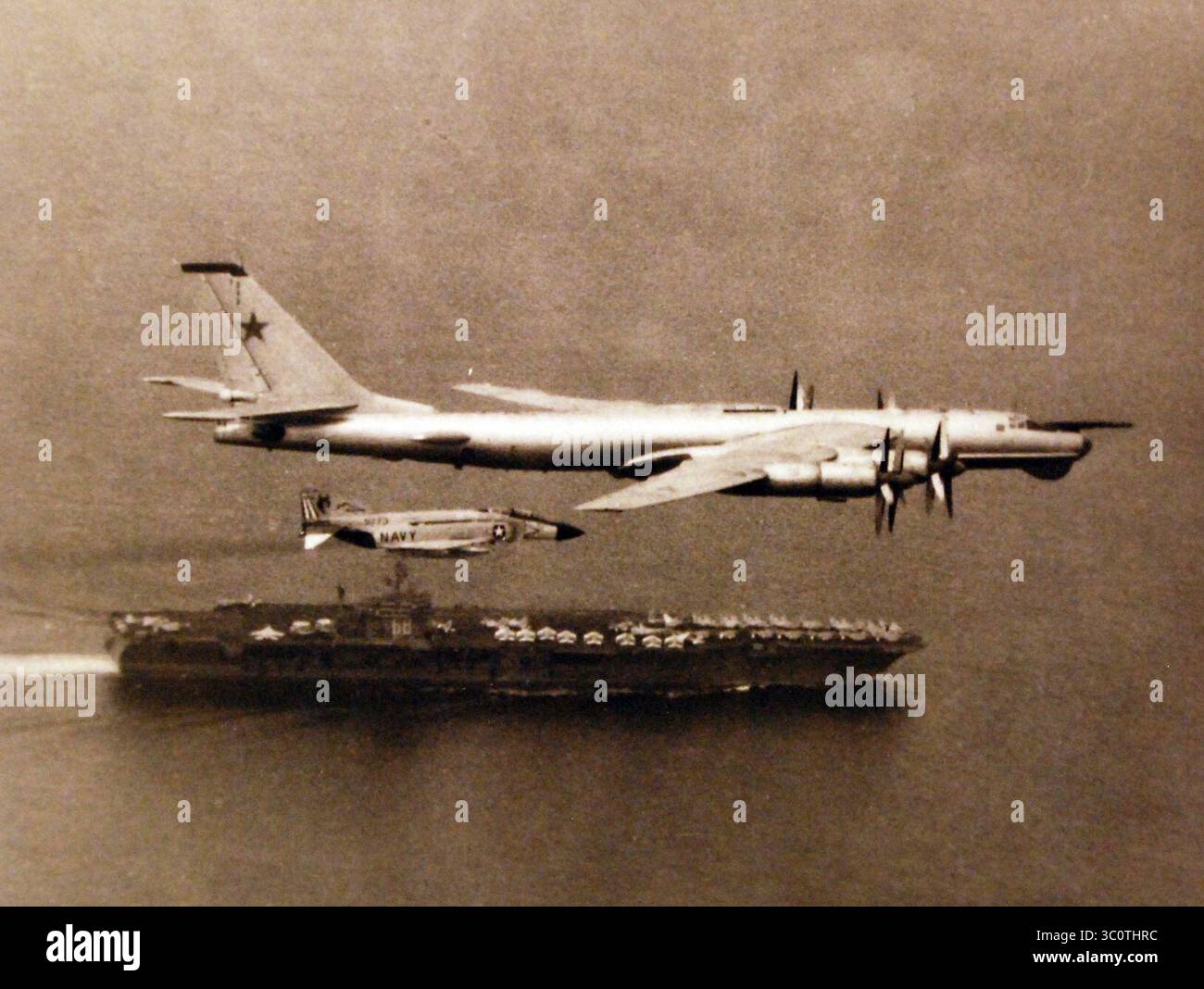 McDonnell Douglas F-4J Phantom II von VF-74 eskortiert den sowjetischen Tupolev Tu-95 über die USS Nimitz (CVN-68), 15. Juli 1976 (428-GX-USN 1169106). Stockfoto
