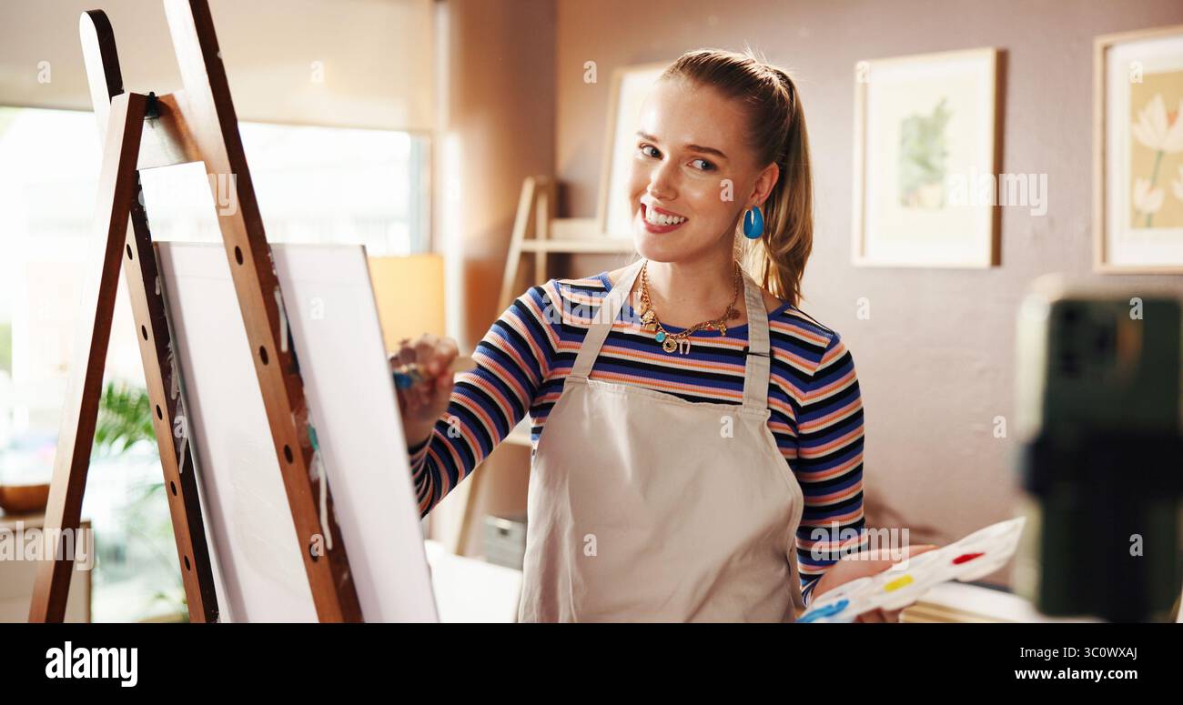 Künstler, Leinwand oder Frau mit Telefon für Live-Streaming im Studio mit kreativen Tipps, Ratschlägen oder Vlog. Influencer, Maler und glücklich mit Videoaufnahmen Stockfoto
