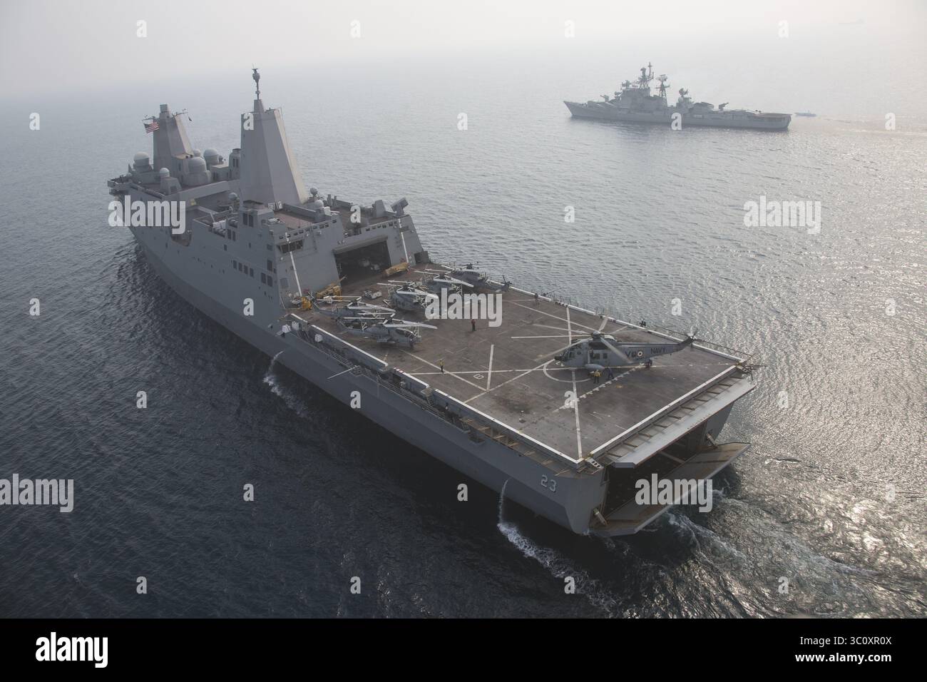 26. Dezember 2018 - USS Anchorage, Indischer Ozean - das amphibische Transportschiff USS Anchorage der San Antonio-Klasse fährt mit einem UH-3H-Hubschrauber der Indischen Marine auf dem Landedeck während kooperativer Übungen mit dem Zerstörer der Indischen Marine IN Rajput, rechts, 26. Dezember 2018 im Indischen Ozean. (Bild: © Sgt. Austin Mealy Via ZUMA Wire) Stockfoto