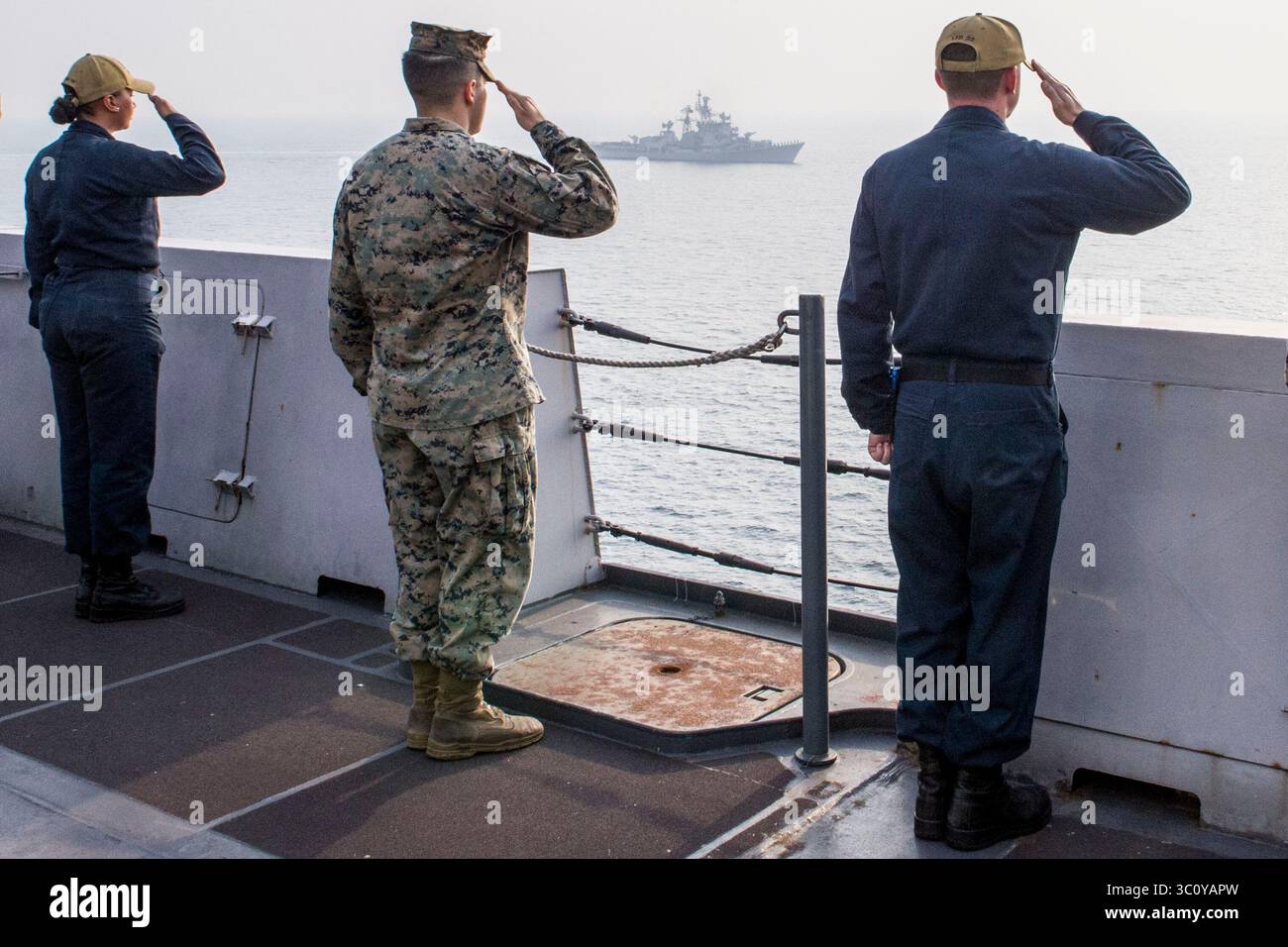 26. Dezember 2018 - Indischer Ozean - Seeleute, die dem Amphibien-Transportschiff USS Anchorage (LPD 23) der San Antonio-Klasse zugeteilt wurden, und Marines, die der 13. Marine Expeditionary Unit (MEU) zugeteilt wurden, verleihen dem Zerstörer der indischen Marine INS Rajput (D 51) während eines kooperativen Einsatzes mit der indischen Marine Ehren. Anchorage ist Teil der Essex Amphibious Ready Group (ARG) und der 13. MEU. Die Essex ARG/13th MEU ist ein fähiges und tödliches Navy-Marine-Corps-Team, das im 7. Flottengebiet eingesetzt wird, um die regionale Stabilität zu unterstützen, Partner und Verbündete zu beruhigen und eine PR zu gewährleisten Stockfoto