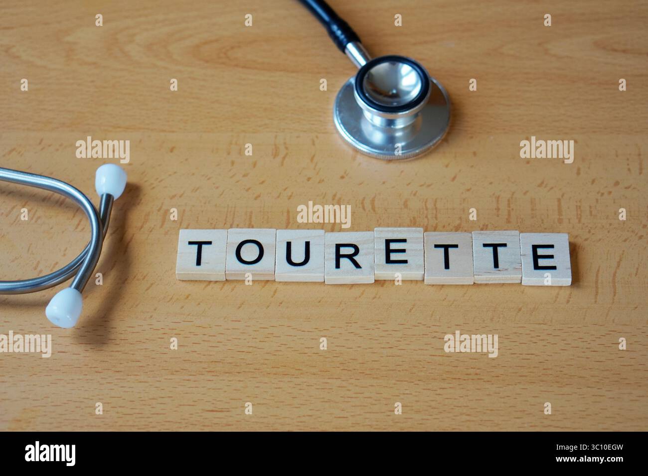 Medizinische Konzepte. tourette. Wort in Holzbuchstaben mit Stethoskop geschrieben. Stockfoto