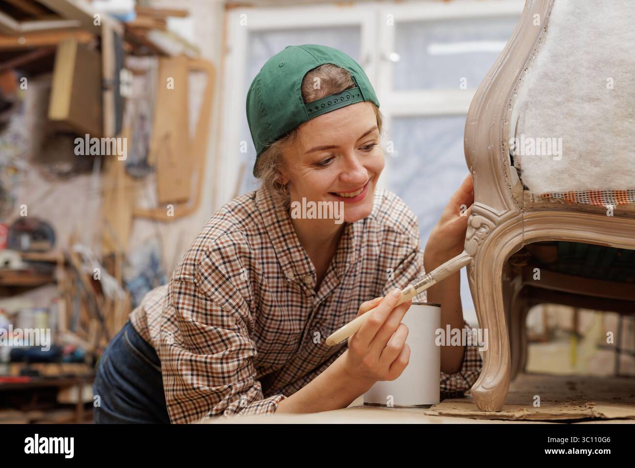 Frau restauriert alten Holzstuhl, Möbelreparatur, Konzept der Reparatur und Restaurierung alter Möbel. Stockfoto