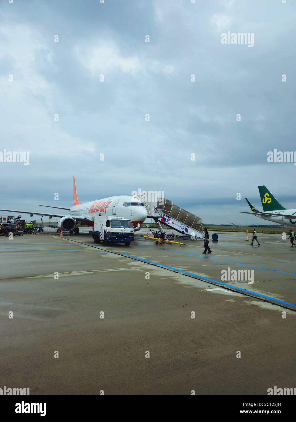 Rainy Day Ground Operations am Kansai International Airport mit Jeju Air Jet Stockfoto