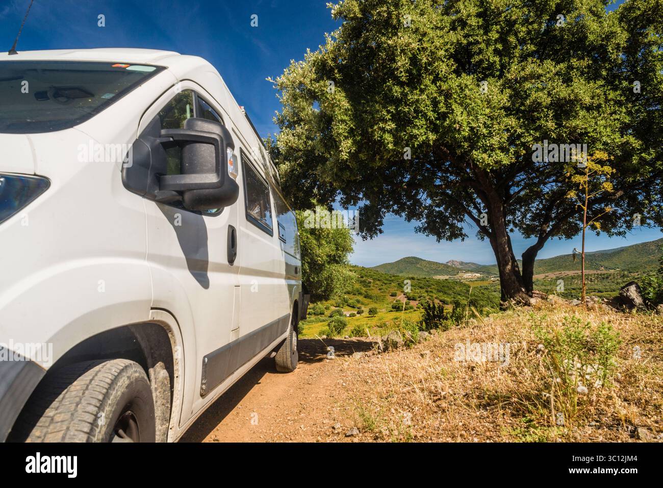 Ein Campingbus fährt Offroad auf einer Piste im Landesinneren von Korsika, Frankreich. Ein Campingbus in der Landschaft *** Ein Wohnmobil fährt Offroad auf einer Feldstraße im Inneren von Korsika, Frankreich Ein Wohnmobil auf dem Land Stockfoto